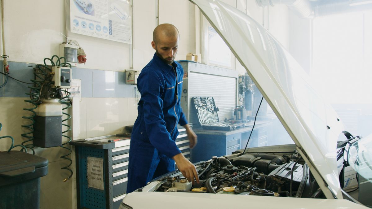 Mecánico inspeccionando el motor de un vehículo durante una revisión técnica